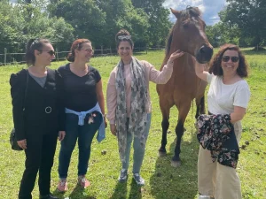 Profesora posando con el equipo de profesoras y el caballa