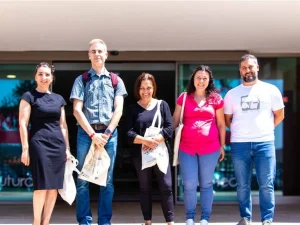 Grupo de profesores sonrientes en la entrada del centro de formación profesional