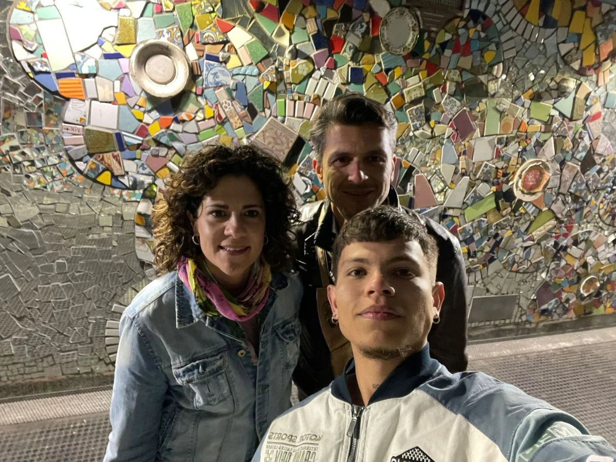 Profesora y profesor con alumno sobre un fondo en mosaico