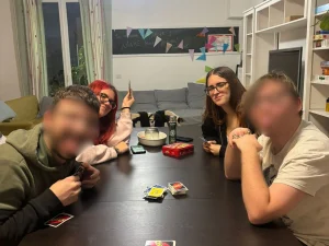 Alumnas jugando a una partida del juego UNO con dos usuarios con discapacidad intelectual